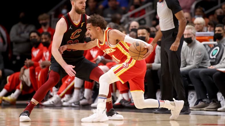 Feb 15, 2022; Atlanta, Georgia, USA; Atlanta Hawks guard Trae Young (11) makes a move against Cleveland Cavaliers forward Dean Wade (32) during the first quarter at State Farm Arena. Mandatory Credit: Jason Getz-USA TODAY Sports