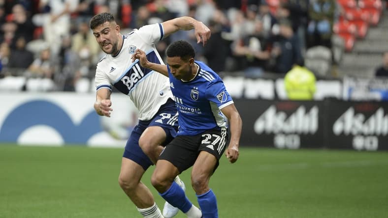 May 14, 2022; Vancouver, British Columbia, CAN;  San Jose Earthquakes defender Marcos Lopez (27) battles for the ball against Vancouver Whitecaps forward Lucas Cavallini (9) during the second half at BC Place. Mandatory Credit: Anne-Marie Sorvin-USA TODAY Sports