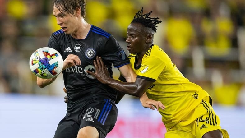 Aug 3, 2022; Columbus, Ohio, USA; CF Montreal midfielder Lassi Lappalainen (21) and Columbus Crew midfielder Yaw Yeboah (14) fight for the ball in the second half at Lower.com Field. Mandatory Credit: Trevor Ruszkowski-USA TODAY Sports