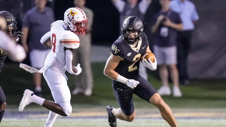 Sep 1, 2022; Winston-Salem, North Carolina, USA; Wake Forest Demon Deacons wide receiver Taylor Morin (2) runs around end chased by Virginia Military Institute Keydets wide receiver Julio DaSilva (9) during the first half at Truist Field. Mandatory Credit: Jim Dedmon-USA TODAY Sports