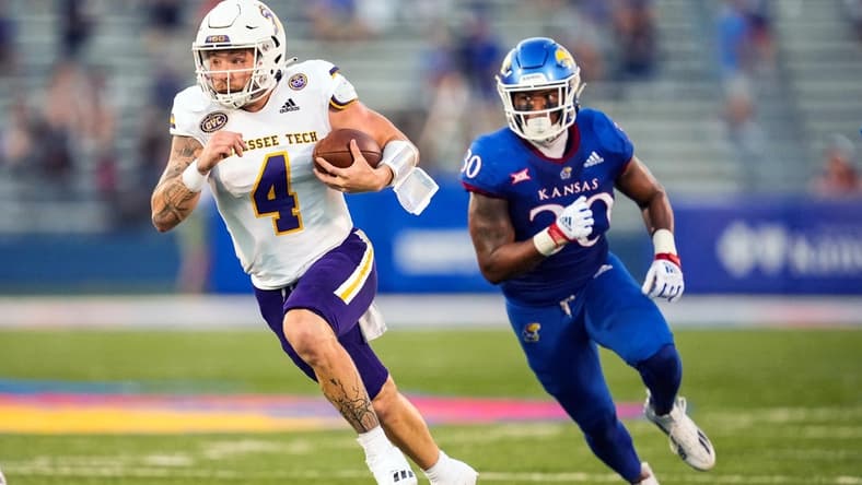 Sep 2, 2022; Lawrence, Kansas, USA; Tennessee Tech Golden Eagles quarterback Jeremiah Oatsvall (4) runs the ball past Kansas Jayhawks linebacker Rich Miller (30) during the first half at David Booth Kansas Memorial Stadium. Mandatory Credit: Jay Biggerstaff-USA TODAY Sports