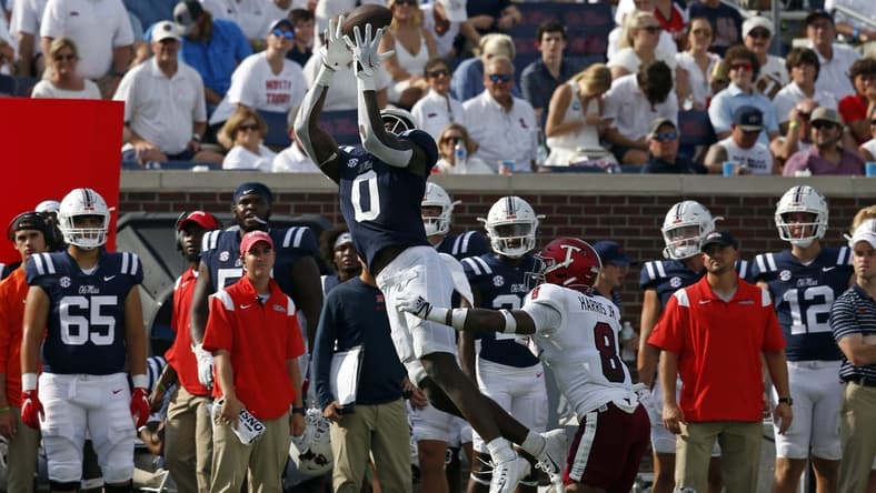 Sep 3, 2022; Oxford, Mississippi, USA; Mississippi Rebels tight end Michael Trigg (0) catches the ball against Troy Trojans defensive back TJ Harris (8) during the second half at Vaught-Hemingway Stadium. Mandatory Credit: Petre Thomas-USA TODAY Sports