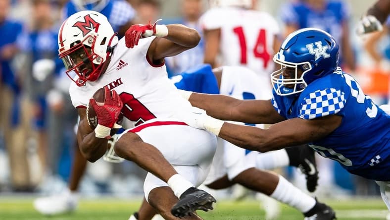 Sep 3, 2022; Lexington, Kentucky, USA; Miami (Oh) Redhawks running back Tyre Shelton (9) runs the ball against Kentucky Wildcats defensive lineman Tre'vonn Rybka (90) during the first quarter at Kroger Field. Mandatory Credit: Jordan Prather-USA TODAY Sports