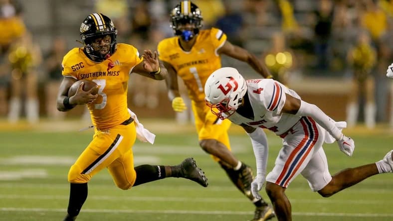 Sep 3, 2022; Hattiesburg, Mississippi, USA; Southern Miss Golden Eagles running back Frank Gore Jr. (3) runs from Liberty Flames cornerback Chris Megginson (4) in the second half at M.M. Roberts Stadium. Liberty won in overtime, 29-27. Mandatory Credit: Chuck Cook-USA TODAY Sports