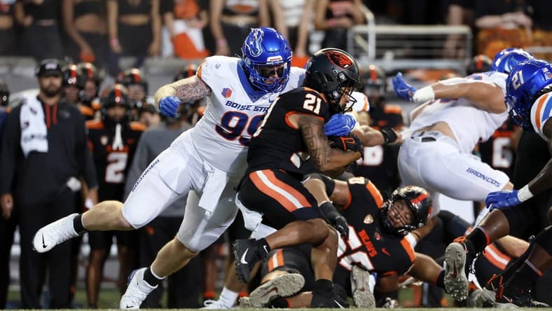 Sep 3, 2022; Corvallis, Oregon, USA; Oregon State Beavers running back Trey Lowe (21) is grabbed by Boise State Broncos defensive tackle Scott Matlock (99) during the first half at Reser Stadium. Mandatory Credit: Soobum Im-USA TODAY Sports