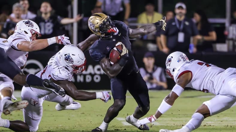 Sep 9, 2022; Orlando, Florida, USA; UCF Knights running back Jordan McDonald (9) is tackled by Louisville Cardinals linebacker Yasir Abdullah (22) during the second quarter at FBC Mortgage Stadium. Mandatory Credit: Mike Watters-USA TODAY Sports