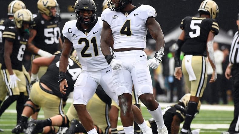 Sep 10, 2022; Nashville, Tennessee, USA; Wake Forest Demon Deacons defensive lineman Jacorey Johns (4) and linebacker Chase Jones (21) celebrate after a defensive stop during the first half against the Vanderbilt Commodores at FirstBank Stadium. Mandatory Credit: Christopher Hanewinckel-USA TODAY Sports