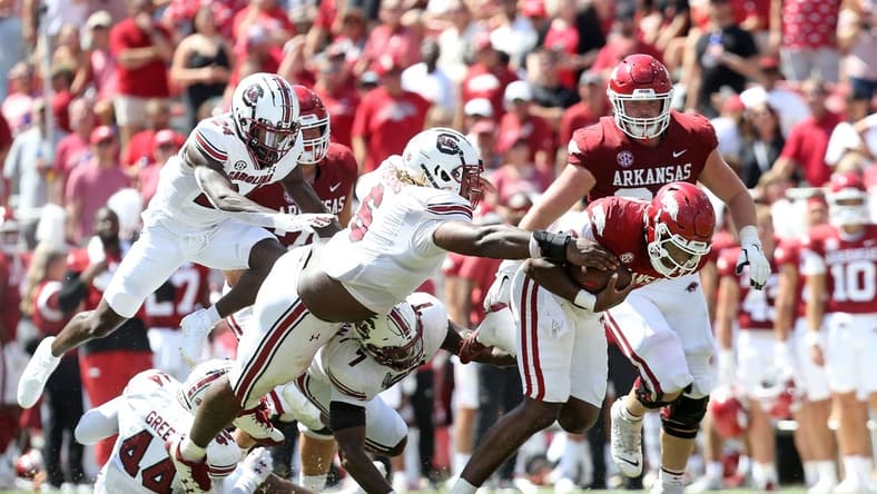 Sep 10, 2022; Fayetteville, Arkansas, USA; Arkansas Razorbacks quarterback KJ Jefferson (1) breaks several tackle attempts in the second quarter as South Carolina Gamecocks defensive lineman Zach Pickens (6) reaches for the ball at Donald W. Reynolds Razorback Stadium. Mandatory Credit: Nelson Chenault-USA TODAY Sports