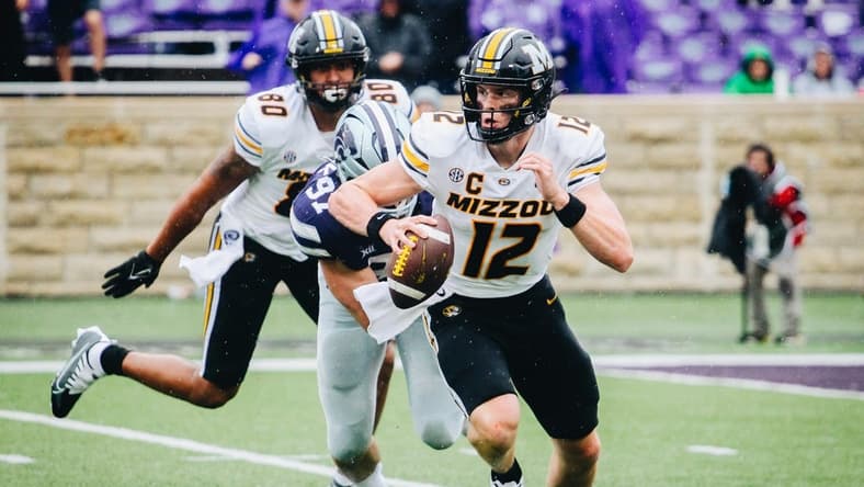 Missouri quarterback Brady Cook (12) runs away from a Kansas State defender during a game against Kansas State at Bill Snyder Family Stadium in Manhattan, Kansas, on Sept. 10, 2022.