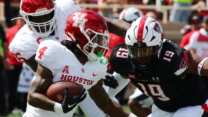 Sep 10, 2022; Lubbock, Texas, USA; Houston Cougars running back Ta Zawn Henry (4) rushes against Texas Tech Red Raiders defensive back Tyree Wilson (19) in the first half at Jones AT&T Stadium and Cody Campbell Field. Mandatory Credit: Michael C. Johnson-USA TODAY Sports