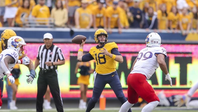 Sep 10, 2022; Morgantown, West Virginia, USA; West Virginia Mountaineers quarterback JT Daniels (18) throws a pass during the first quarter against the Kansas Jayhawks at Mountaineer Field at Milan Puskar Stadium. Mandatory Credit: Ben Queen-USA TODAY Sports