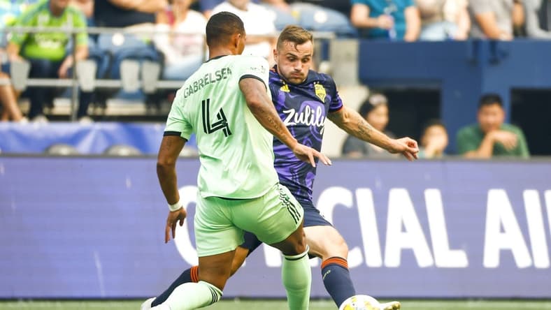 Sep 10, 2022; Seattle, Washington, USA; Austin FC defender Ruben Gabrielsen (4) clears the ball away from Seattle Sounders FC forward Jordan Morris (13) during the first half at Lumen Field. Mandatory Credit: Joe Nicholson-USA TODAY Sports
