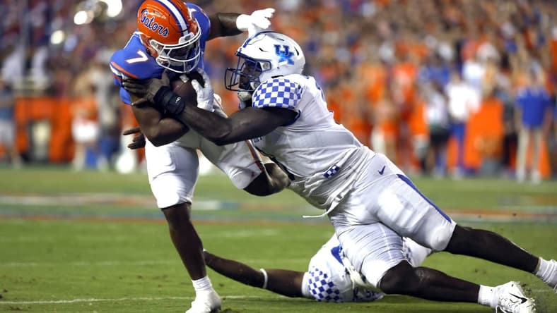Sep 10, 2022; Gainesville, Florida, USA; Florida Gators running back Trevor Etienne (7) runs with the ball as Kentucky Wildcats defensive tackle Octavious Oxendine (8) tackles during the first half at Ben Hill Griffin Stadium. Mandatory Credit: Kim Klement-USA TODAY Sports