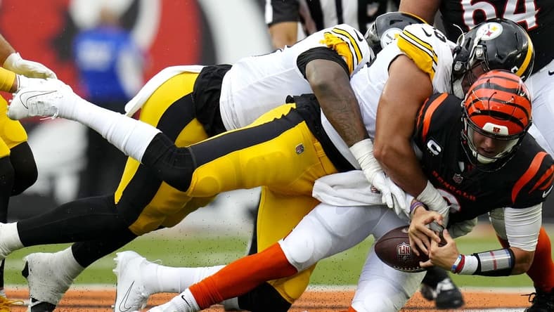 Sep 11, 2022; Cincinnati, Ohio, USA; Cincinnati Bengals quarterback Joe Burrow (9) is sacked by Pittsburgh Steelers linebacker Alex Highsmith (56) during the first quarter of a Week 1 NFL football game at Paycor Stadium. Mandatory Credit: Sam Greene-USA TODAY Sports