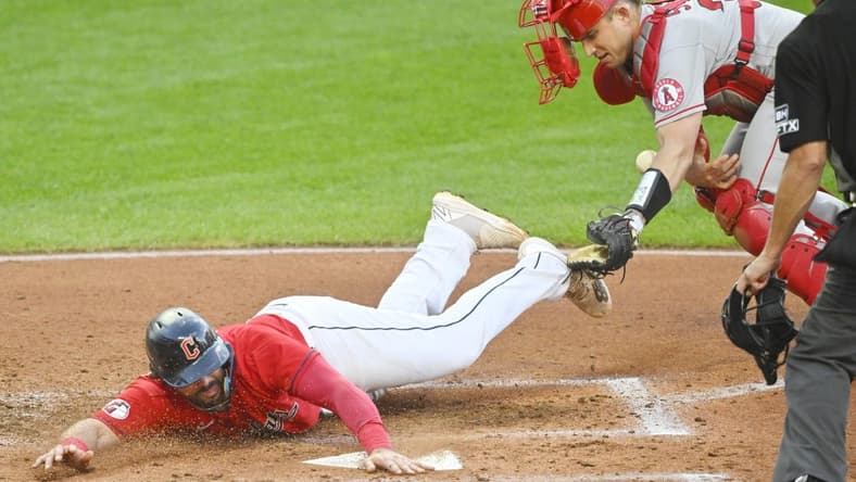 Sep 12, 2022; Cleveland, Ohio, USA; Cleveland Guardians catcher Austin Hedges (17) scores beside Los Angeles Angels catcher Max Stassi (33) in the second inning at Progressive Field. Mandatory Credit: David Richard-USA TODAY Sports