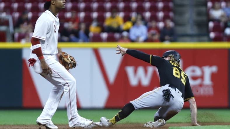 Sep 12, 2022; Cincinnati, Ohio, USA; Pittsburgh Pirates right fielder Jack Suwinski (65) slides safely second base after a bunt single against Cincinnati Reds shortstop Jose Barrero (2) during the fourth inning at Great American Ball Park. Mandatory Credit: David Kohl-USA TODAY Sports