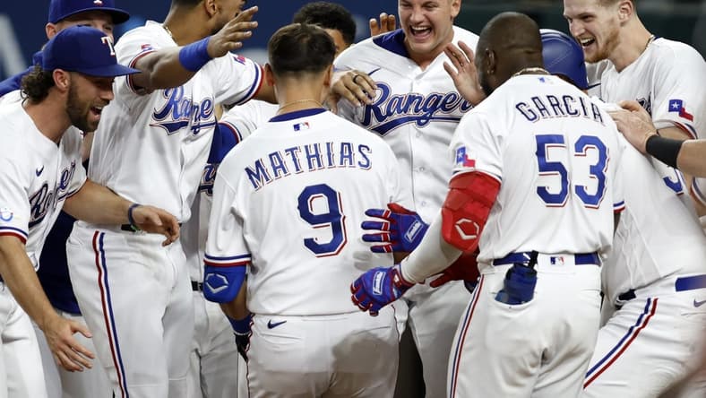 Sep 13, 2022; Arlington, Texas, USA; Texas Rangers first baseman Mark Mathias (9) is congratulated by his teammates after he hit the game-winning home run against the Oakland Athletics in the bottom of the ninth inning at Globe Life Field. Mandatory Credit: Tim Heitman-USA TODAY Sports
