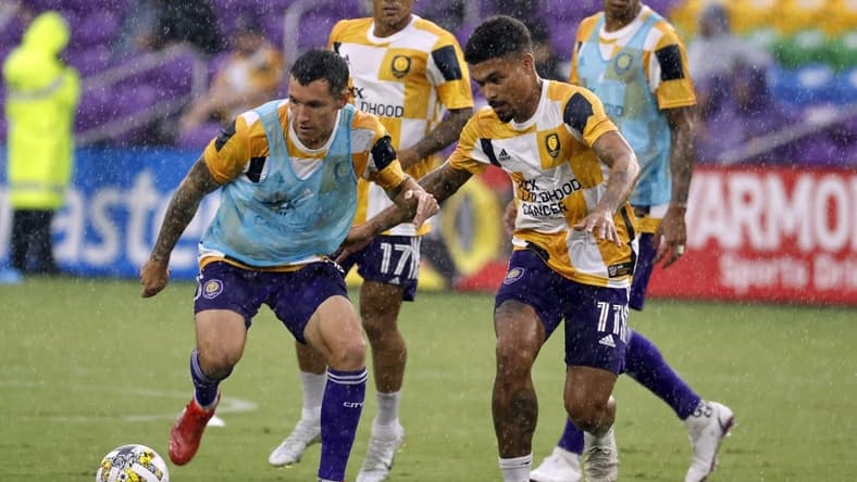 Sep 14, 2022; Orlando, Florida, USA; Orlando City SC defender Kyle Smith (24) and midfielder J  nior Urso (11) work out prior to a game against Atlanta United FC at Exploria Stadium. Mandatory Credit: Kim Klement-USA TODAY Sports