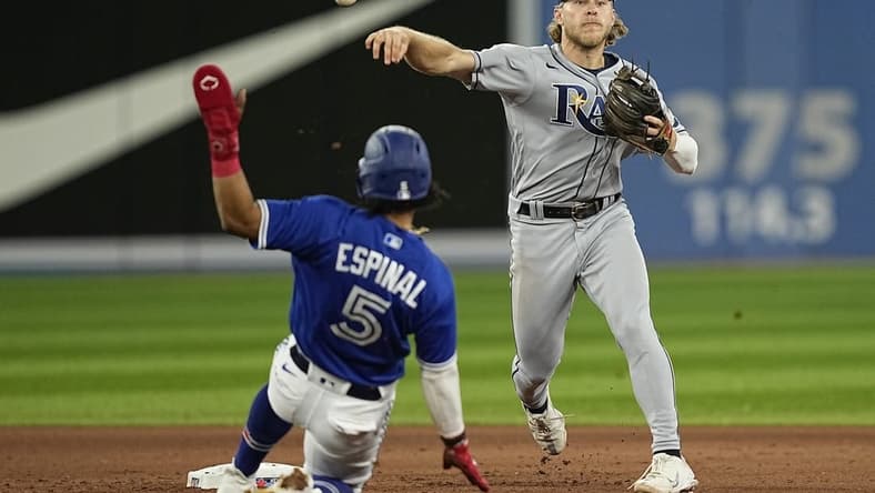 Sep 14, 2022; Toronto, Ontario, CAN; Tampa Bay Rays shortstop Taylor Walls (0) turns a double play on Toronto Blue Jays second baseman Santiago Espinal (5) and Toronto Blue Jays right fielder Jackie Bradley (not pictured) during the fourth inning at Rogers Centre. Mandatory Credit: John E. Sokolowski-USA TODAY Sports