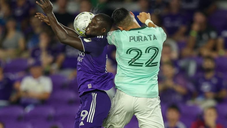 Sep 14, 2022; Orlando, Florida, USA;  Orlando City forward Benji Michel (19) and Atlanta United defender Juan Jose Purata (22) jumps fro a header in the second half at Exploria Stadium. Mandatory Credit: Nathan Ray Seebeck-USA TODAY Sports