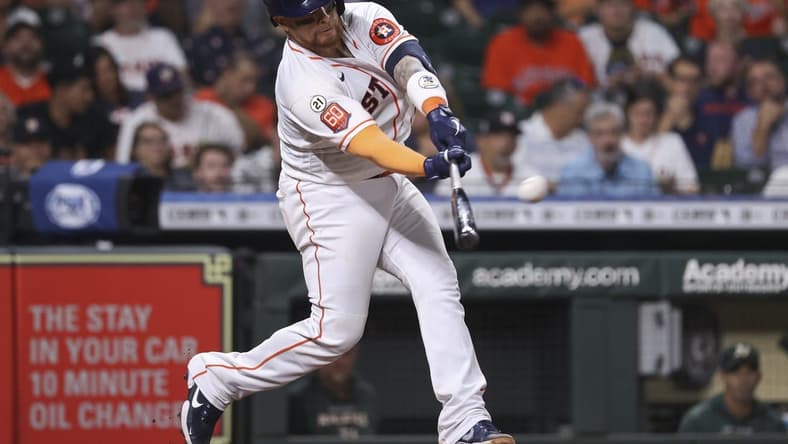 Sep 15, 2022; Houston, Texas, USA; Houston Astros catcher Christian Vazquez (21) hits an RBI double during the fourth inning against the Oakland Athletics at Minute Maid Park. Mandatory Credit: Troy Taormina-USA TODAY Sports