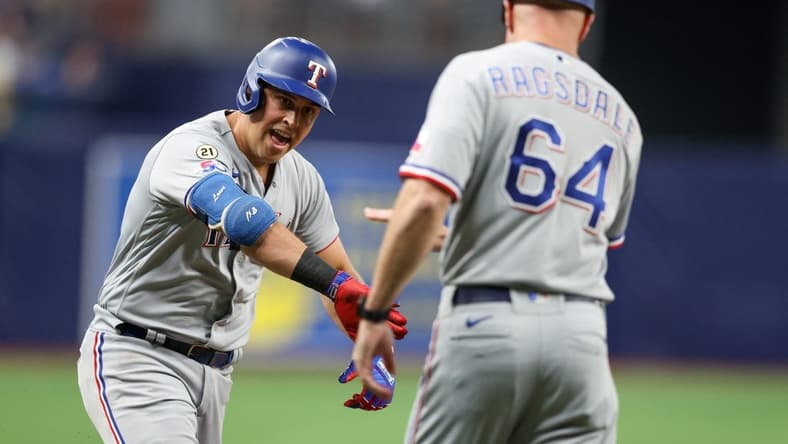 Sep 16, 2022; St. Petersburg, Florida, USA;  Texas Rangers first baseman Nathaniel Lowe (30) is congratulated by third base coach Corey Ragsdale (64) after hitting a two-run home run against the Tampa Bay Rays in the third inning at Tropicana Field. Mandatory Credit: Nathan Ray Seebeck-USA TODAY Sports