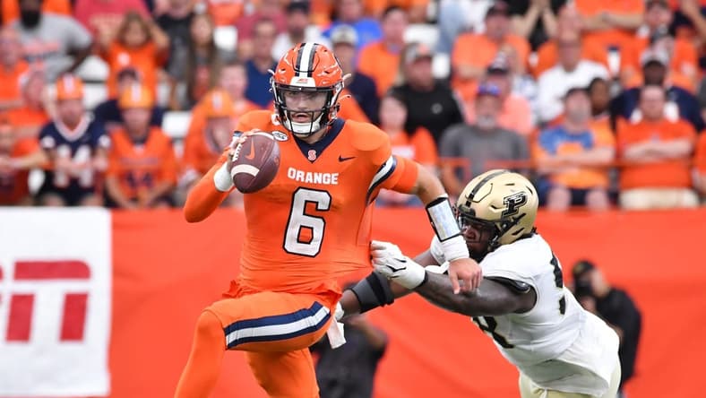 Sep 17, 2022; Syracuse, New York, USA; Syracuse Orange quarterback Garrett Shrader (6) avoids a tackle by Purdue Boilermakers defensive tackle Branson Deen (58) in the third quarter at JMA Wireless Dome. Mandatory Credit: Mark Konezny-USA TODAY Sports