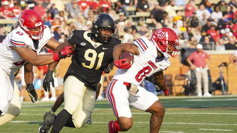 Sep 17, 2022; Winston-Salem, North Carolina, USA;  Liberty Flames running back Dae Dae Hunter (0) runs with the ball past Wake Forest Demon Deacons defensive lineman Kevin Pointer (91) during the first half at Truist Field. Mandatory Credit: James Guillory-USA TODAY Sports