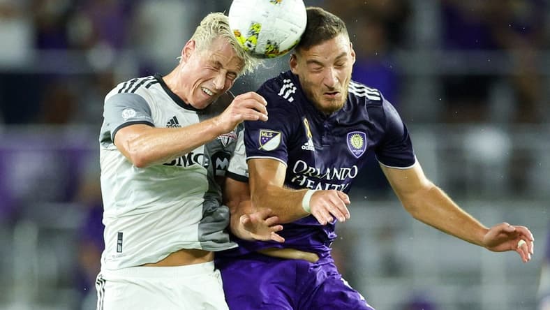 Sep 17, 2022; Orlando, Florida, USA;  Orlando City forward Ercan Kara (9) and Toronto FC defender Lukas MacNaughton (5) head the ball in the first half at Exploria Stadium. Mandatory Credit: Nathan Ray Seebeck-USA TODAY Sports