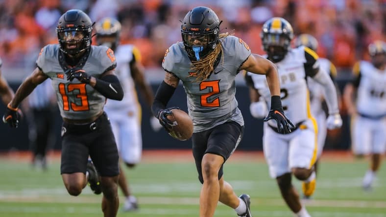 Sep 17, 2022; Stillwater, Oklahoma, USA; Oklahoma State Cowboys cornerback Korie Black (2) picks up a blocked kick and returns it for a touchdown against the Arkansas-Pine Bluff Golden Lions in the first half at Boone Pickens Stadium. Mandatory Credit: Nathan J. Fish-USA TODAY Sports