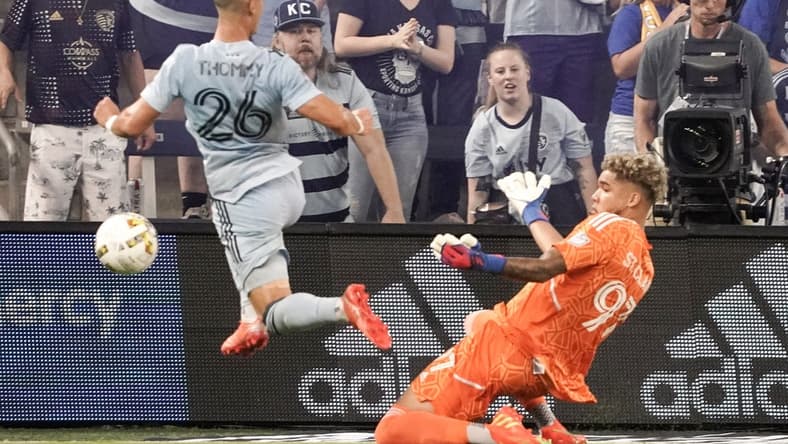 Sep 17, 2022; Kansas City, Kansas, USA; Sporting Kansas City midfielder Eric Thammy (26) kicks a shot on goal as Minnesota United goalkeeper Dayne St. Clair (97) defends during the first half of the match at Children's Mercy Park. Mandatory Credit: Denny Medley-USA TODAY Sports