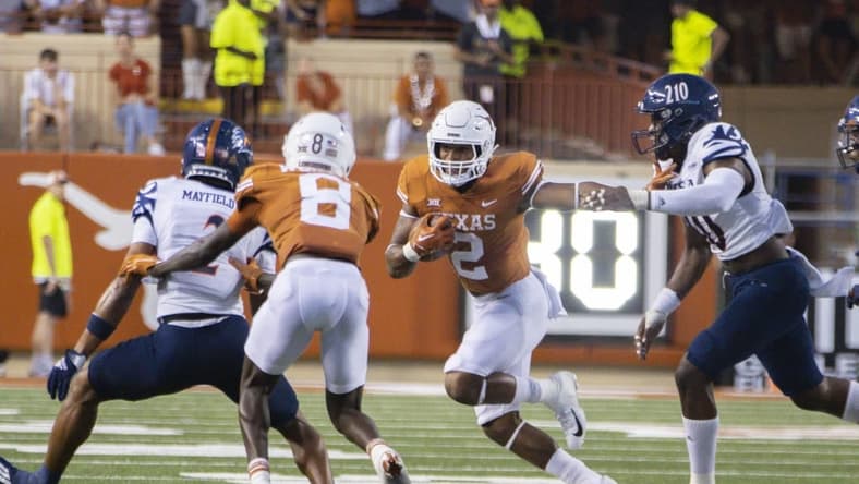 Sep 17, 2022; Austin, Texas, USA; Texas Longhorns running back Roschon Johnson (2) carries for extra yards against the UTSA Roadrunner defense during the first quarter at Darrell K Royal-Texas Memorial Stadium. Mandatory Credit: John Gutierrez-USA TODAY Sports