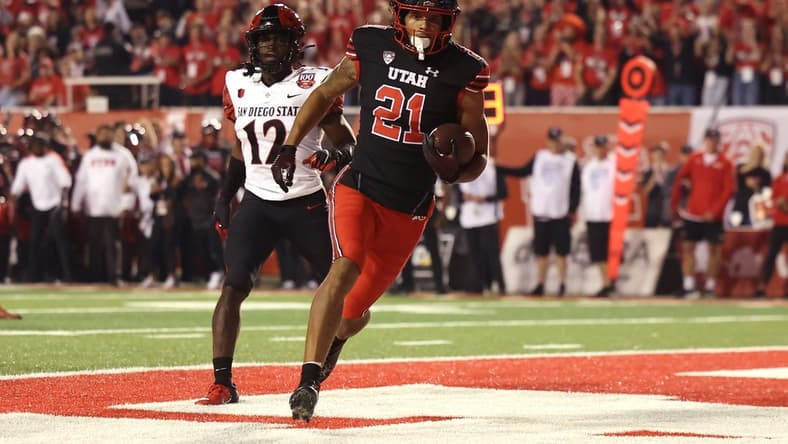 Sep 17, 2022; Salt Lake City, Utah, USA; Utah Utes wide receiver Solomon Enis (21) scores a touchdown against San Diego State Aztecs cornerback Dallas Branch (12) in the second quarter at Rice-Eccles Stadium. Mandatory Credit: Rob Gray-USA TODAY Sports