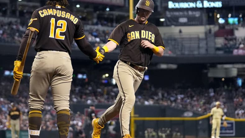 Sep 17, 2022; Phoenix, Arizona, USA; San Diego Padres player Jake Cronenworth (9) celebrates with teammate Luis Campusano (12) after scoring a run against the Arizona Diamondbacks at Chase Field. Mandatory Credit: Joe Rondone-Arizona Republic