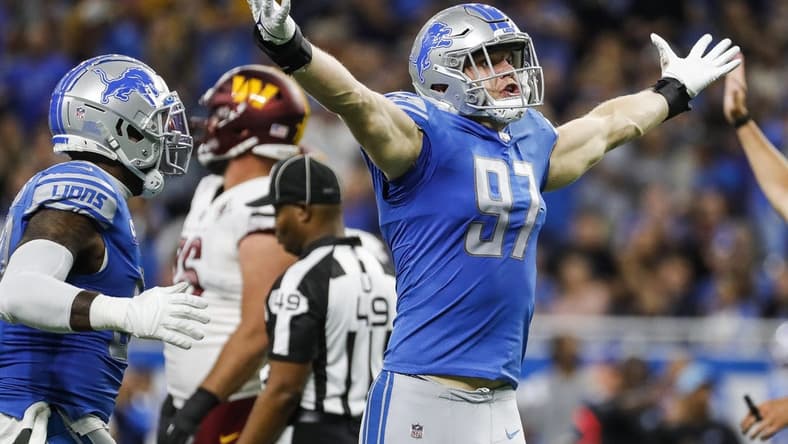 Sep 18, 2022; Detroit, Michigan, USA;  Detroit Lions defensive end Aidan Hutchinson (97) celebrates a sack against  Washington Commanders quarterback Carson Wentz (11) during the first half at Ford Field. Mandatory Credit: Junfu Han-USA TODAY Sports