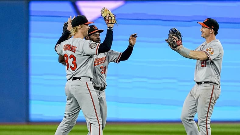 Sep 18, 2022; Toronto, Ontario, CAN; Baltimore Orioles left fielder Kyle Stowers (83) and center fielder Cedric Mullins (31) and right fielder Austin Hays (21) celebrate a win over the Toronto Blue Jays at the end of the ninth inning at Rogers Centre. Mandatory Credit: John E. Sokolowski-USA TODAY Sports