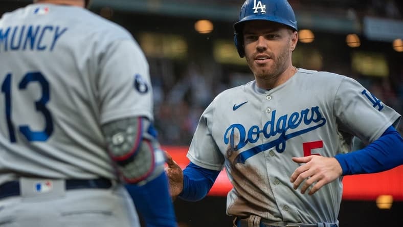 Sep 18, 2022; San Francisco, California, USA;  Los Angeles Dodgers first baseman Freddie Freeman (5) high fives third baseman Max Muncy (13) after scoring during the fourth inning against the San Francisco Giants at Oracle Park. Mandatory Credit: Ed Szczepanski-USA TODAY Sports
