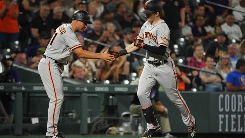 Sep 19, 2022; Denver, Colorado, USA; San Francisco Giants center fielder Mike Yastrzemski (5) is congratulated for his solo home run by third base coach Mark Hallberg (91) in the fourth inning against the Colorado Rockies at Coors Field. Mandatory Credit: Ron Chenoy-USA TODAY Sports