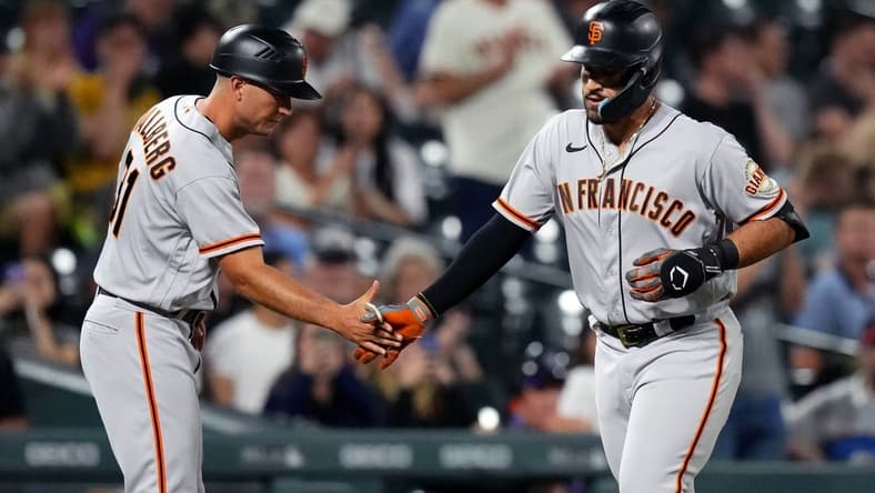 Sep 20, 2022; Denver, Colorado, USA; San Francisco Giants third baseman David Villar (70) is congratulated for his solo home run by third base coach Mark Hallberg (91) in the seventh inning at Coors Field. Mandatory Credit: Ron Chenoy-USA TODAY Sports