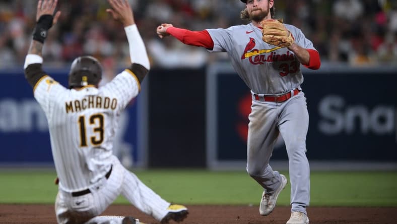 Sep 20, 2022; San Diego, California, USA; St. Louis Cardinals second baseman Brendan Donovan (33) throws to first base after forcing out San Diego Padres third baseman Manny Machado (13) at second base to complete a double play during the fifth inning at Petco Park. Mandatory Credit: Orlando Ramirez-USA TODAY Sports