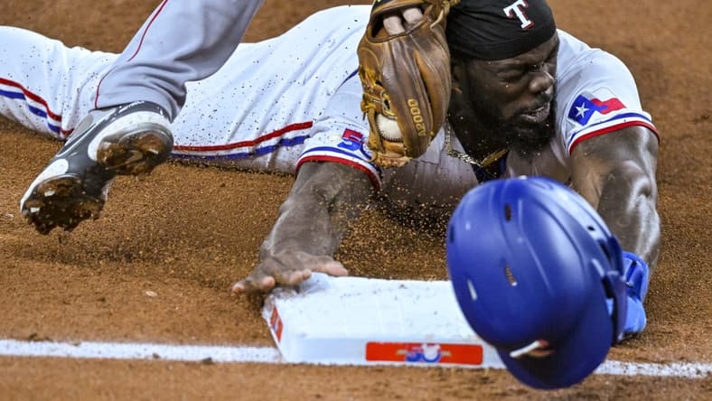 Sep 21, 2022; Arlington, Texas, USA; Texas Rangers designated hitter Adolis Garcia (53) is tagged out after he caught attempting to steal third base during the third inning against the Los Angeles Angels at Globe Life Field. Mandatory Credit: Jerome Miron-USA TODAY Sports