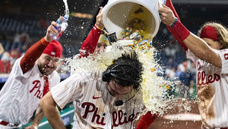 Sep 21, 2022; Philadelphia, Pennsylvania, USA; Philadelphia Phillies center fielder Matt Vierling (19) is doused by liquid and bubble gum after hitting a walk off RBI single during the tenth inning against the Toronto Blue Jays at Citizens Bank Park. Mandatory Credit: Bill Streicher-USA TODAY Sports
