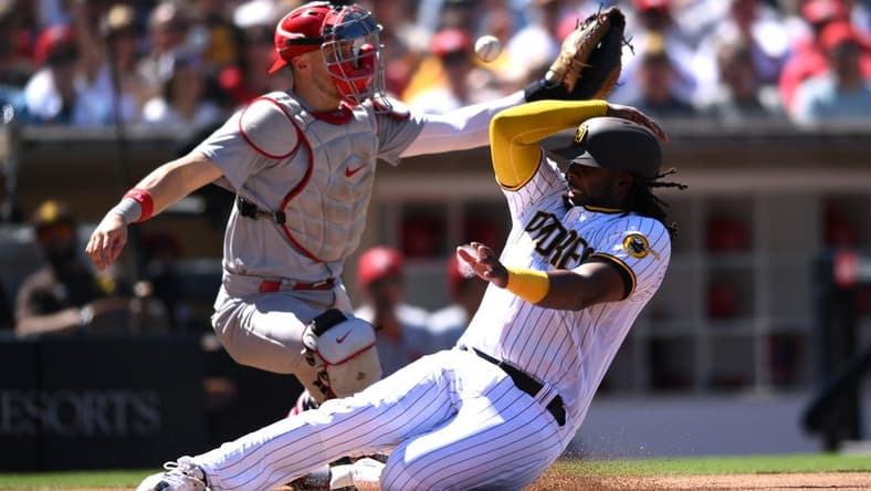 Sep 22, 2022; San Diego, California, USA; San Diego Padres designated hitter Josh Bell (right) slides home to score a run ahead of the throw to St. Louis Cardinals catcher Andrew Knizner (left) during the second inning at Petco Park. Mandatory Credit: Orlando Ramirez-USA TODAY Sports