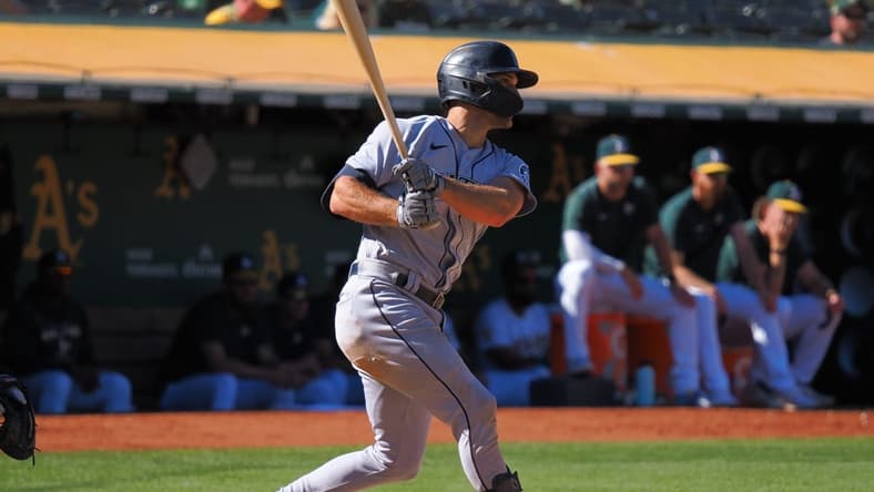 Sep 22, 2022; Oakland, California, USA; Seattle Mariners second baseman Adam Frazier (26) hits an RBI single against the Oakland Athletics during the eighth inning at RingCentral Coliseum. Mandatory Credit: Kelley L Cox-USA TODAY Sports
