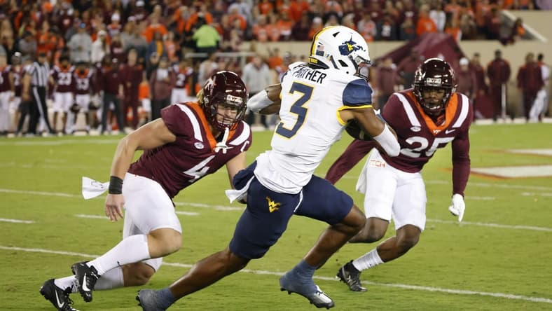Sep 22, 2022; Blacksburg, Virginia, USA; West Virginia Mountaineers wide receiver Kaden Prather (3) runs the ball between Virginia Tech Hokies linebacker Dax Hollifield (4) and defensive back Chamarri Conner (25) at Lane Stadium. Mandatory Credit: Reinhold Matay-USA TODAY Sports