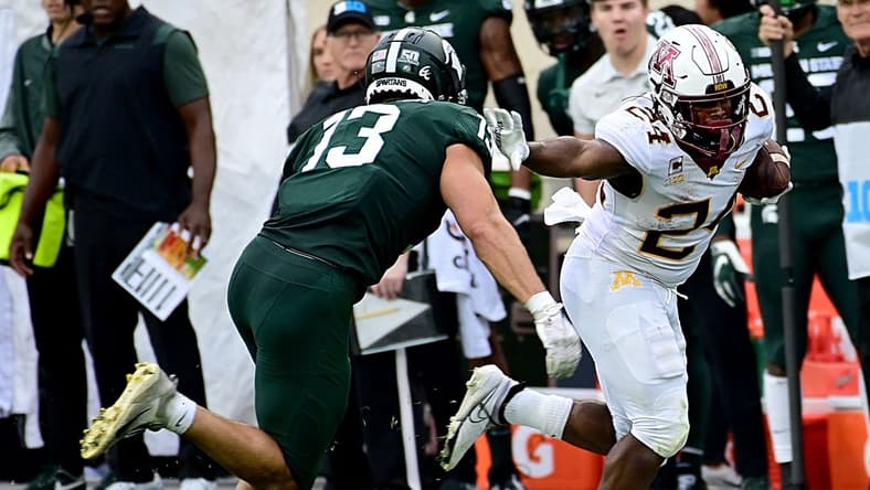Sep 24, 2022; East Lansing, Michigan, USA; Minnesota Golden Gophers running back Mohamed Ibrahim (24) pushes away tackler Michigan State Spartans linebacker Ben VanSumeren (13) in the second quarter at Spartan Stadium. Mandatory Credit: Dale Young-USA TODAY Sports