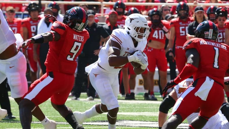 Sep 24, 2022; Lubbock, Texas, USA;  Texas Longhorns running back Roschon Johnson (2) rushes against Texas Tech Red Raiders defensive back Krishon Merriweather (1) in the first half at Jones AT&T Stadium and Cody Campbell Field. Mandatory Credit: Michael C. Johnson-USA TODAY Sports