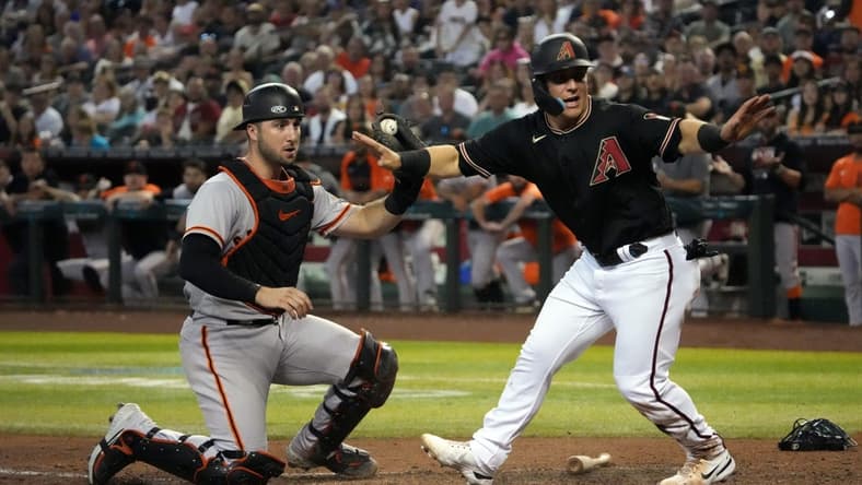 Sep 24, 2022; Phoenix, Arizona, USA; Arizona Diamondbacks right fielder Daulton Varsho (12) beats a throw to San Francisco Giants catcher Joey Bart (21) to score a run during the fourth inning at Chase Field. Mandatory Credit: Joe Camporeale-USA TODAY Sports