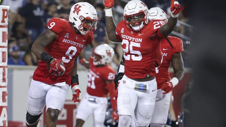Sep 24, 2022; Houston, Texas, USA; Houston Cougars defensive lineman Nelson Ceaser (9) celebrates with linebacker Jamal Morris (25) after returning a fumbled ball for a touchdown during the fourth quarter against the Rice Owls at TDECU Stadium. Mandatory Credit: Troy Taormina-USA TODAY Sports