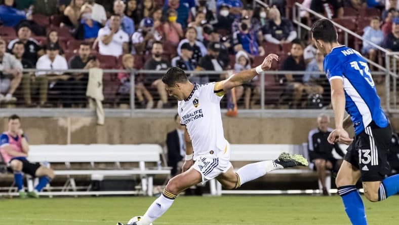Sep 24, 2022; Stanford, California, USA; Los Angeles Galaxy forward Javier Hern  ndez (14) shoots and scores a goal as San Jose Earthquakes defender Nathan (13) defends during the second half at Stanford Stadium. Mandatory Credit: John Hefti-USA TODAY Sports